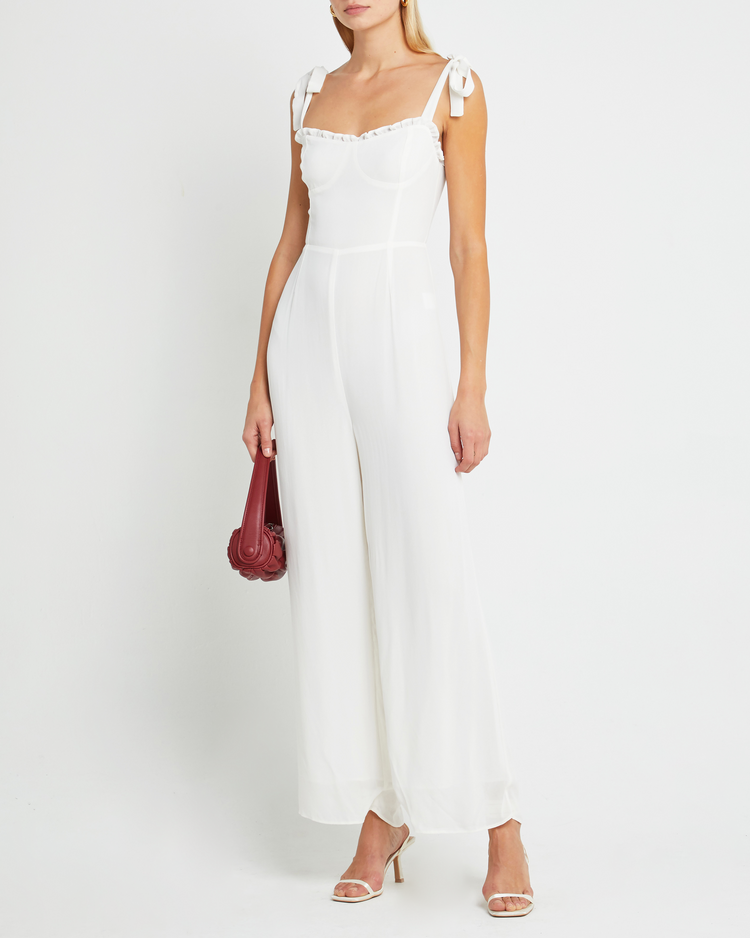 Fourth image of Blair Jumpsuit, a white jumpsuit with straight-leg lined pants, adjustable tie straps, cup detail, neckline ruffles, and a back zipper